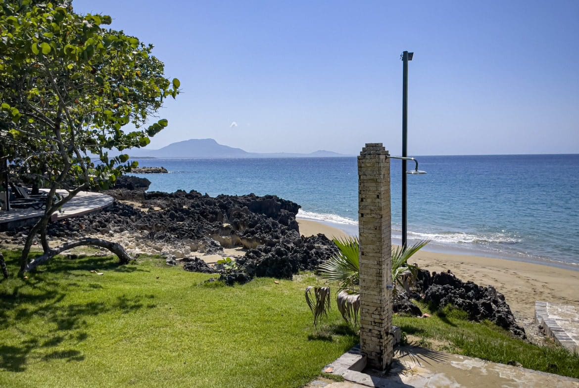 buyDRproperty Oceanfront view from a condo in Sosua with a beach and clear blue water. Sosua Real Estate
