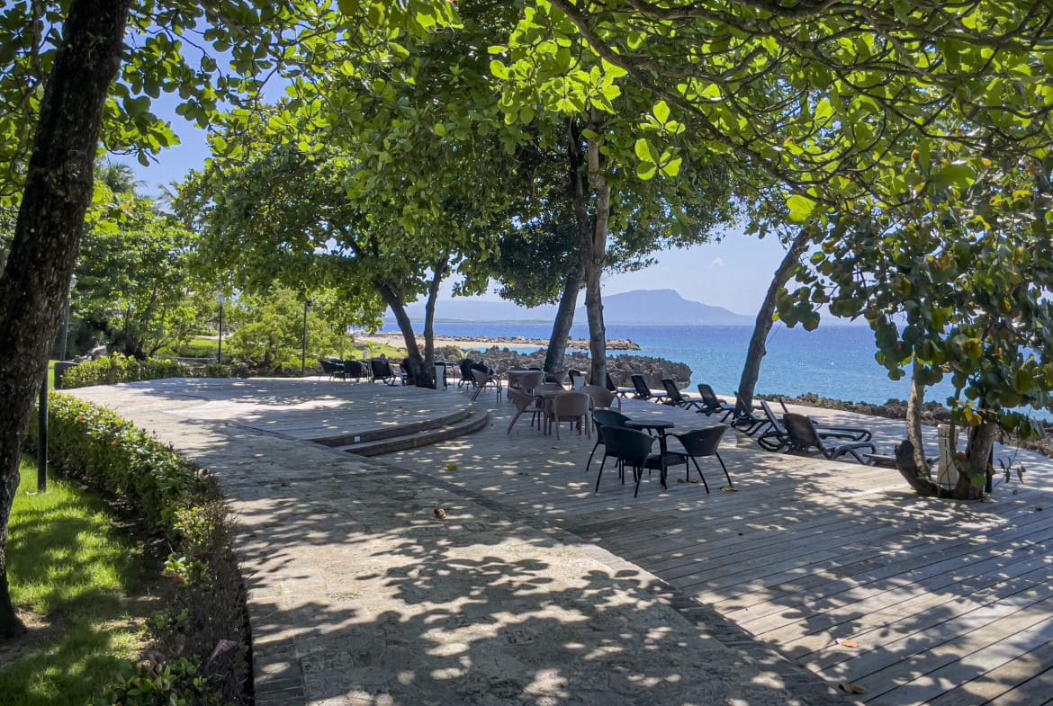 buyDRproperty Oceanfront seating area in Sosua, with tables, chairs, and a view of the ocean Sosua Real Estate