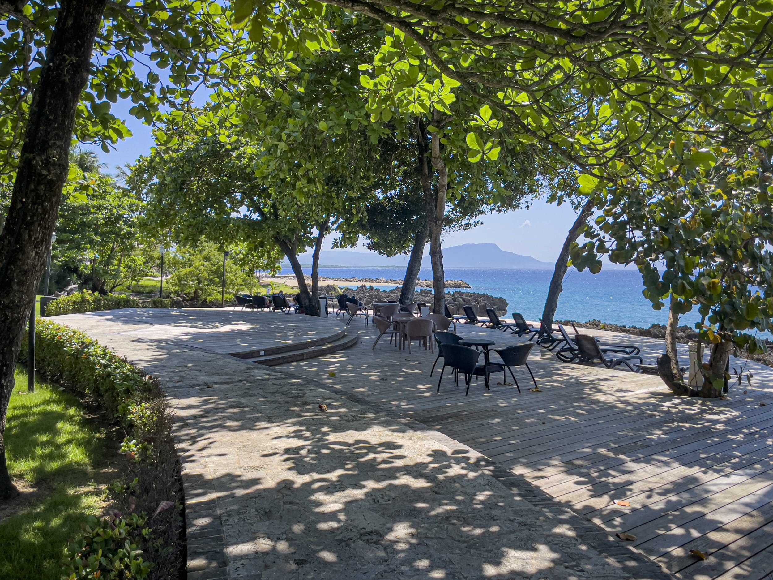 buyDRproperty Oceanfront seating area in Sosua, with tables, chairs, and a view of the ocean Sosua Real Estate