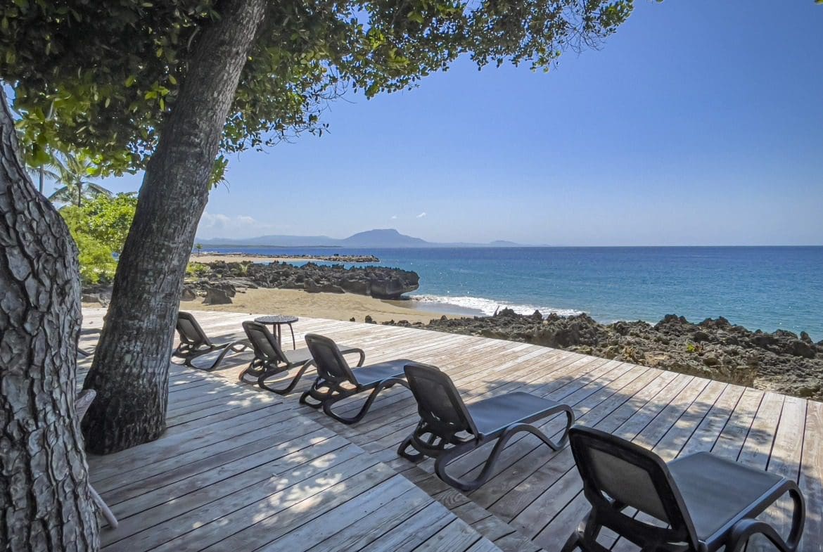 buyDRproperty Lounge chairs on a wooden deck overlooking Sosua beach in the Dominican Republic Sosua Real Estate