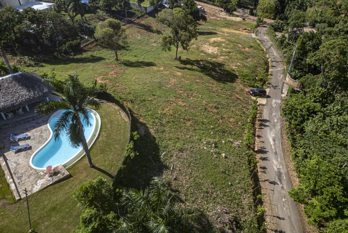 buyDRproperty Aerial view of a beautiful ocean view lot with pool and road in Sosua Sosua Real Estate