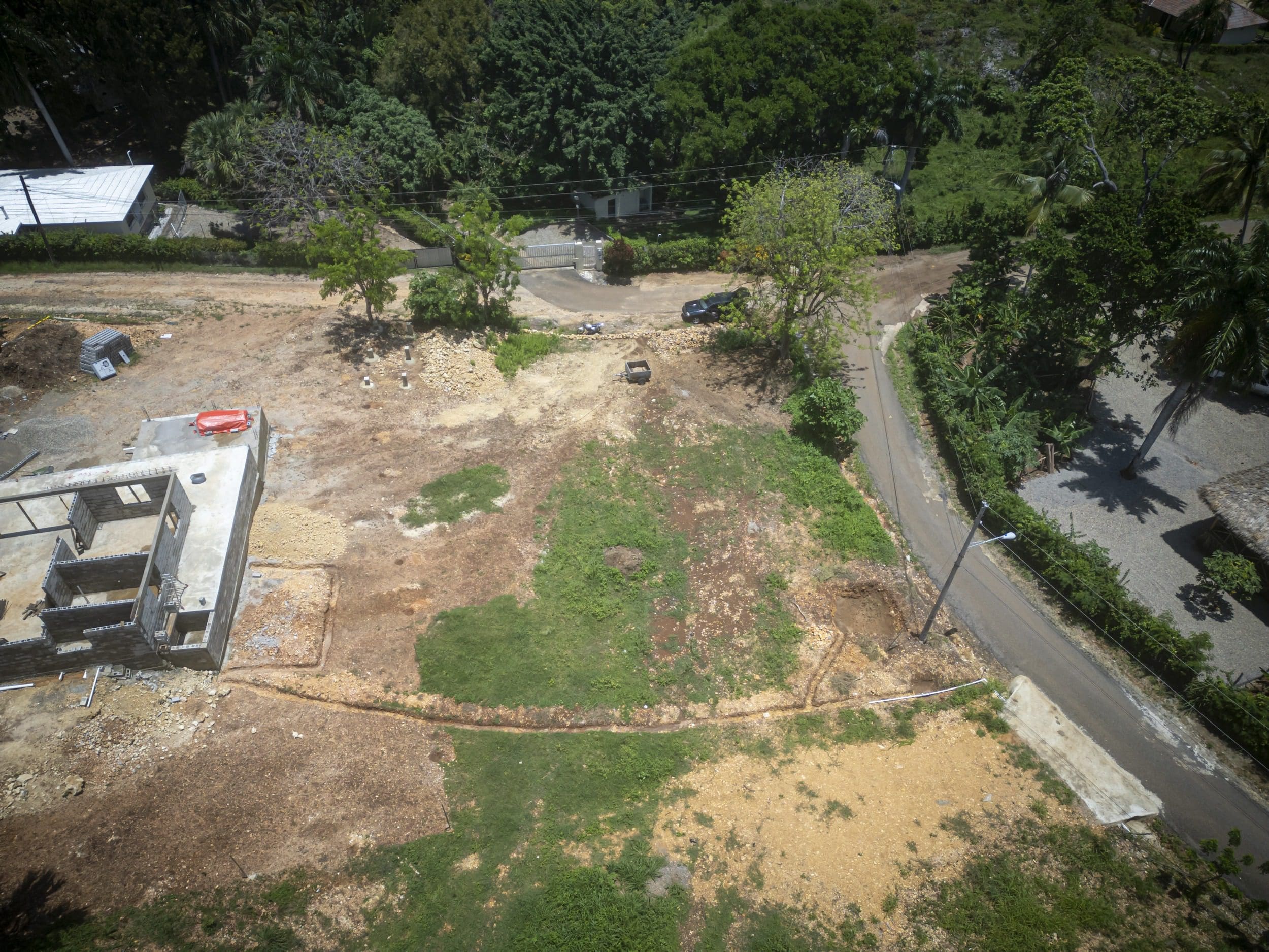 buyDRproperty Aerial view of a country side building lot in Sosua with a partially built structure. Sosua Real Estate