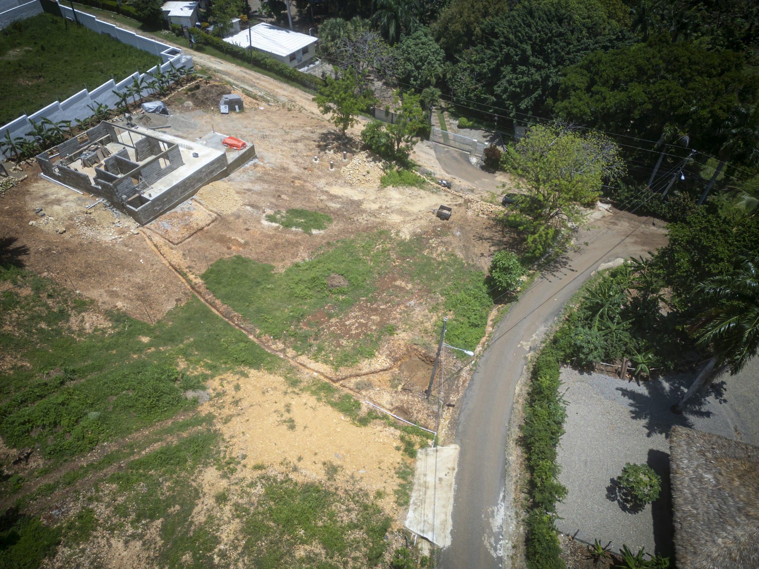 buyDRproperty Aerial view of a building lot in Sosua with a house under construction. Sosua Real Estate