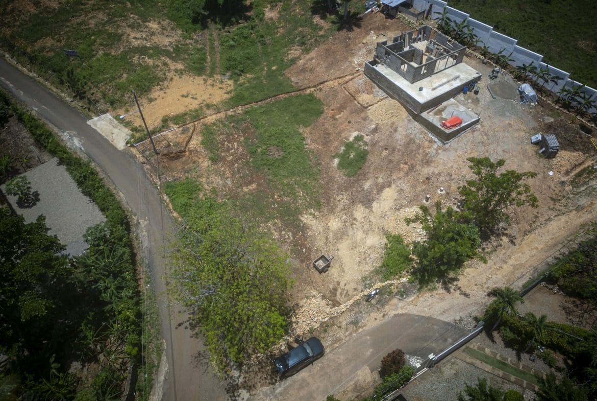 buyDRproperty Aerial view of a building lot in Sosua, with a house under construction. Sosua Real Estate