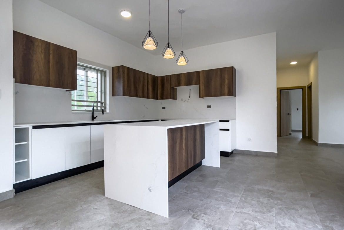 buyDRproperty Modern kitchen in a villa for sale with white cabinets and wood accents. Sosua Real Estate