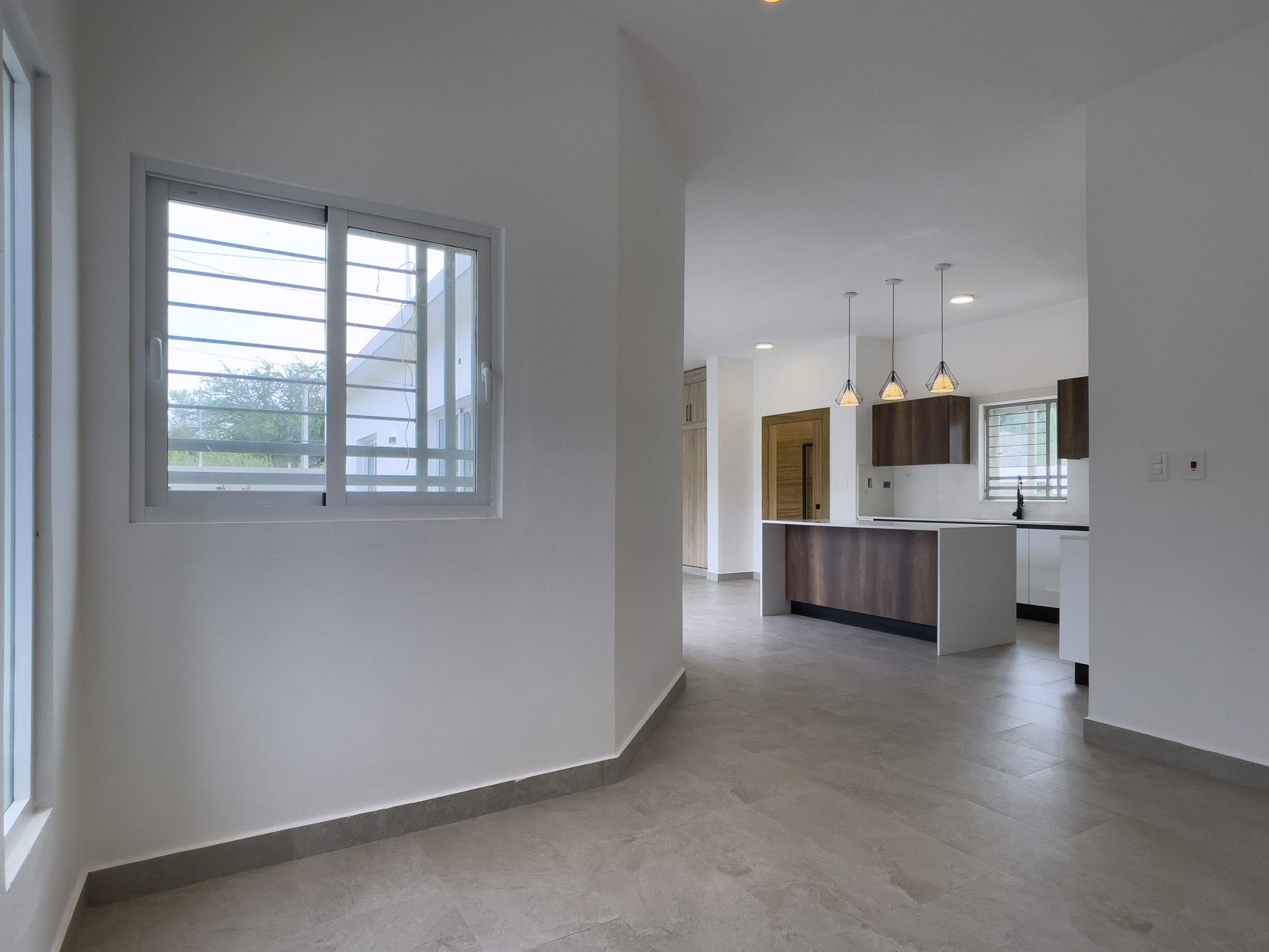 buyDRproperty Modern kitchen in a villa for sale with island and pendant lights. Sosua Real Estate