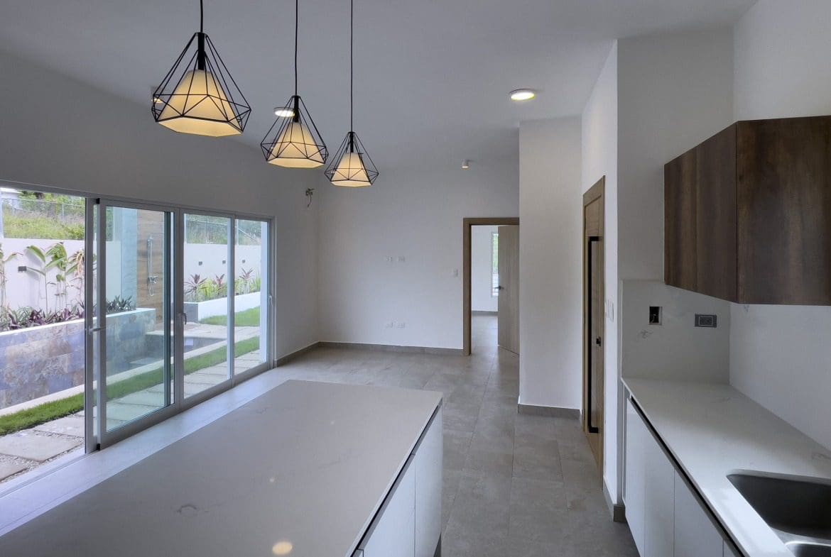 buyDRproperty Modern villa interior with kitchen island and pendant lights. Villa for sale. Sosua Real Estate