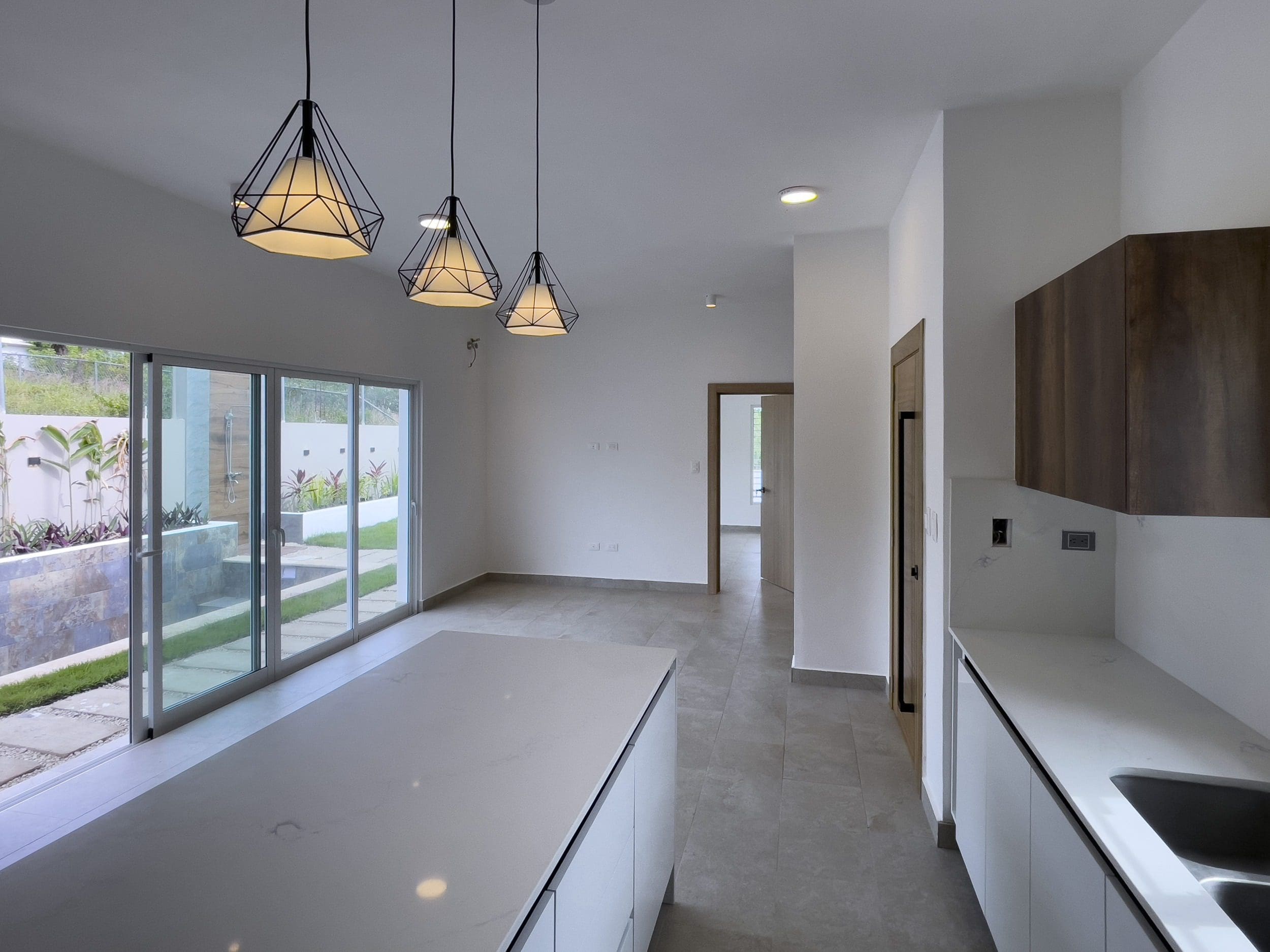buyDRproperty Modern villa interior with kitchen island and pendant lights. Villa for sale. Sosua Real Estate