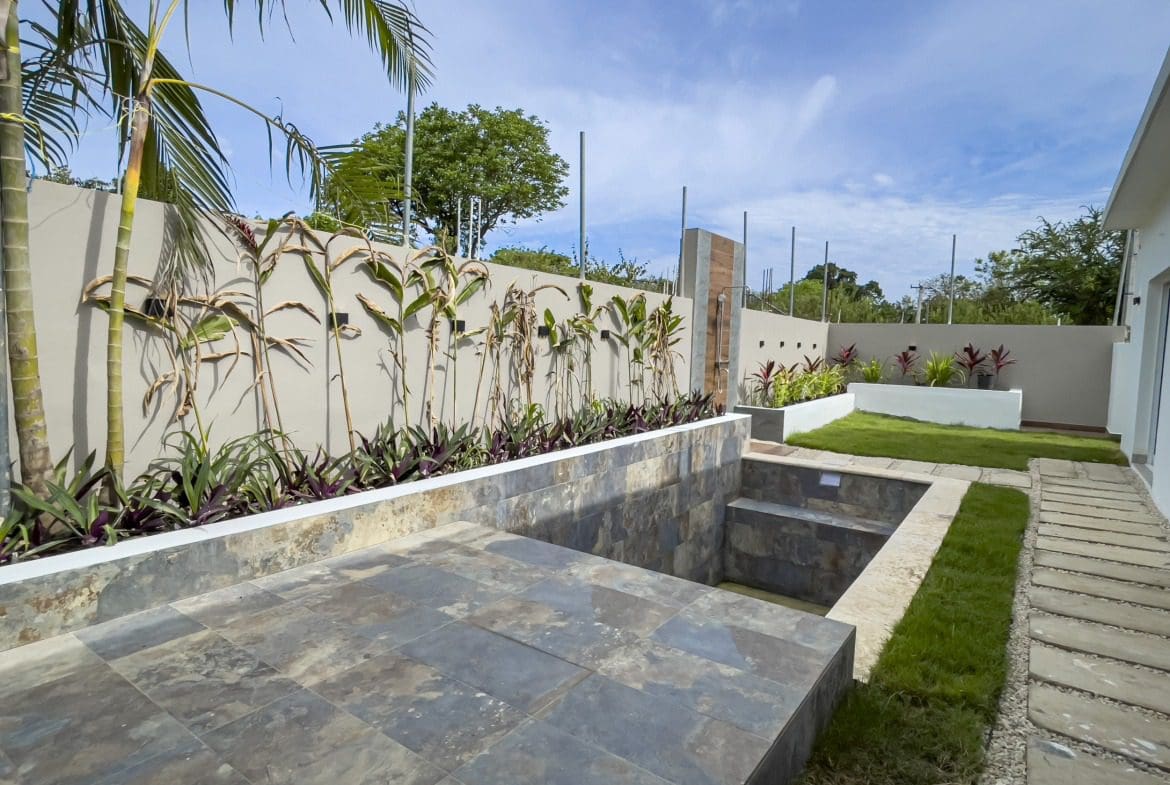 buyDRproperty Modern villa for sale in Sosua Hills, featuring a stylish outdoor patio and garden. Sosua Real Estate