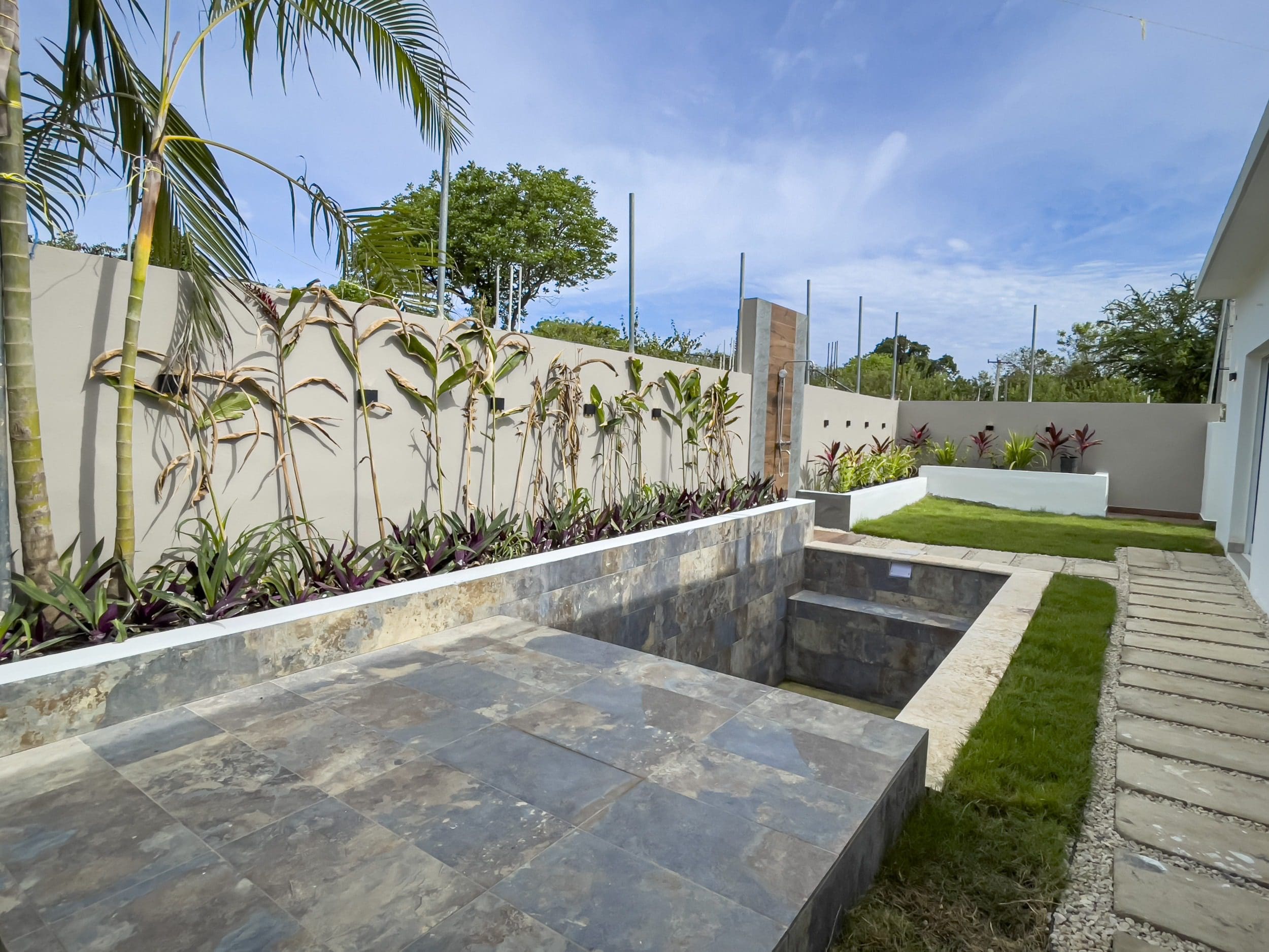 buyDRproperty Modern villa for sale in Sosua Hills, featuring a stylish outdoor patio and garden. Sosua Real Estate