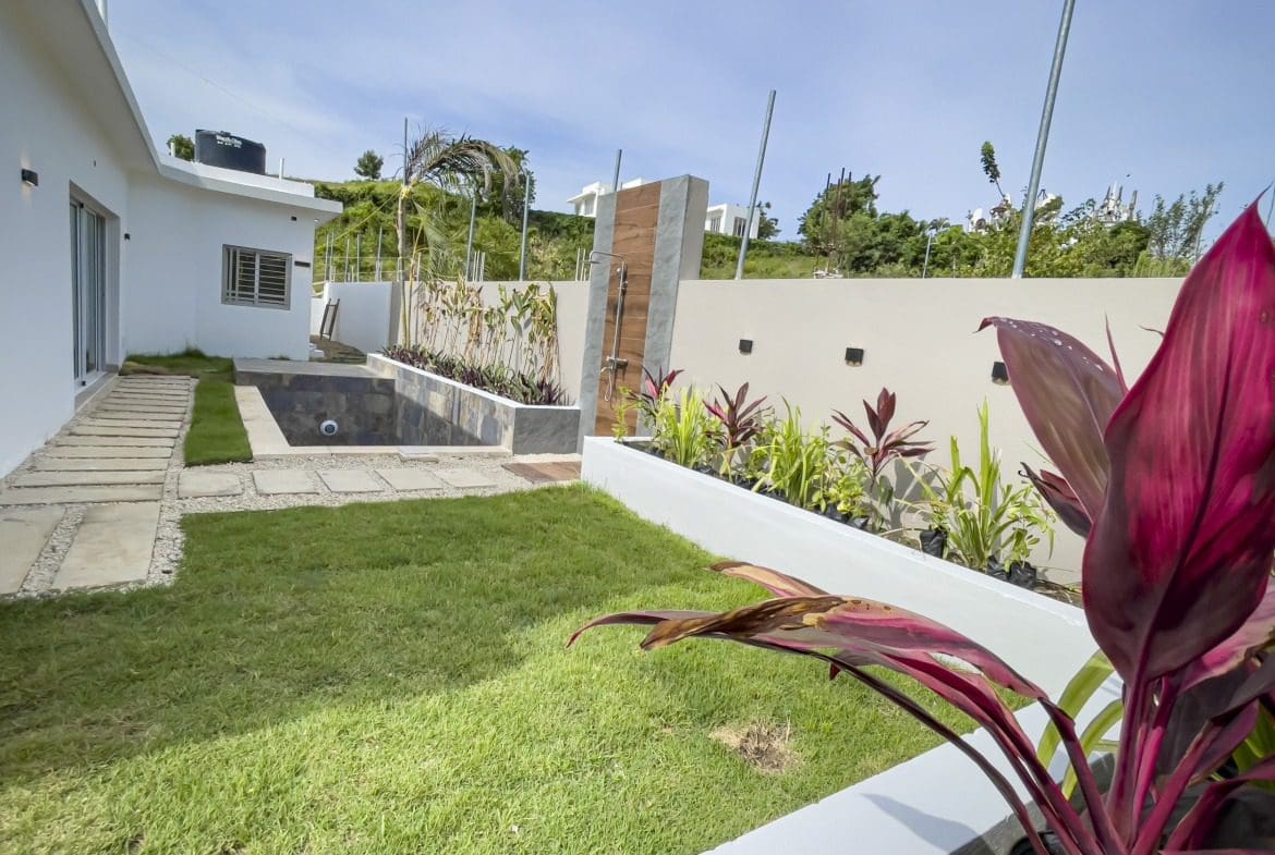 buyDRproperty Modern villa for sale in Sosua Hills with pool and lush landscaping. Sosua Real Estate