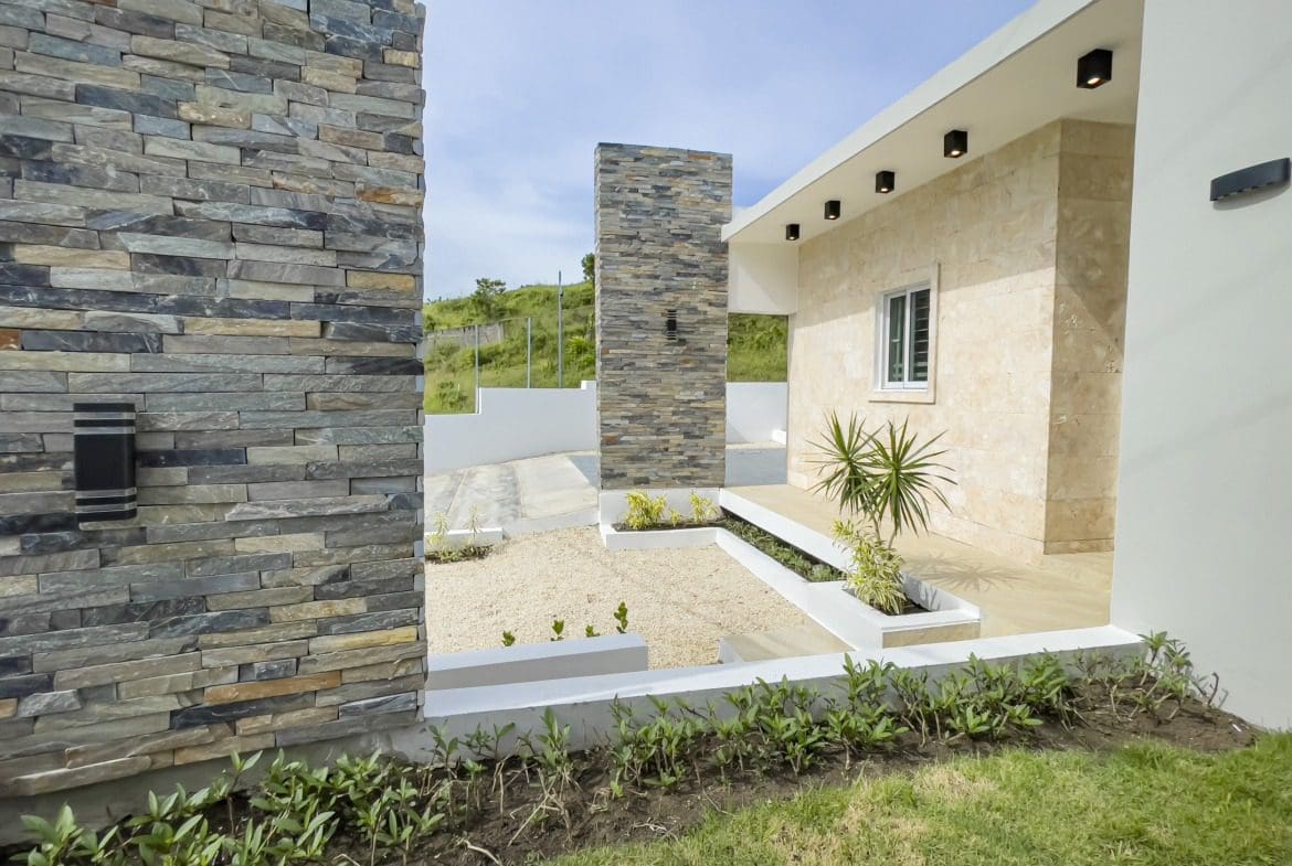 buyDRproperty Modern villa for sale in Sosua Hills with stone wall and landscaping Sosua Real Estate