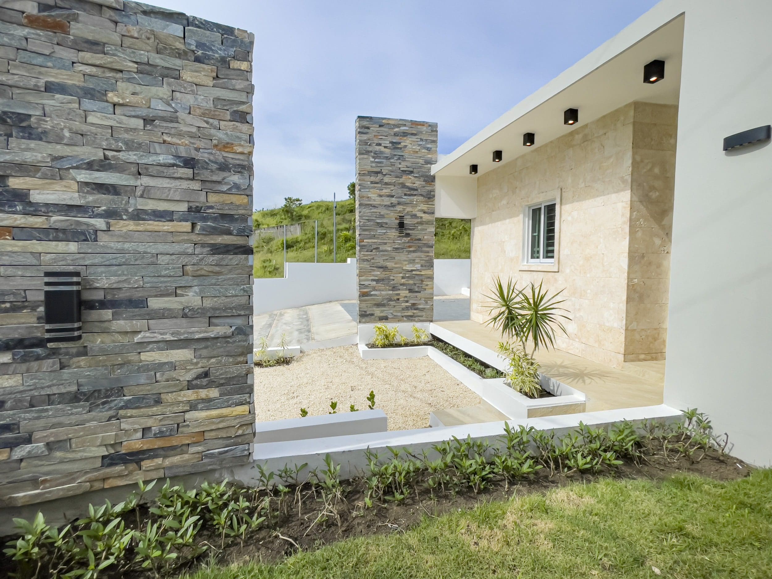buyDRproperty Modern villa for sale in Sosua Hills with stone wall and landscaping Sosua Real Estate