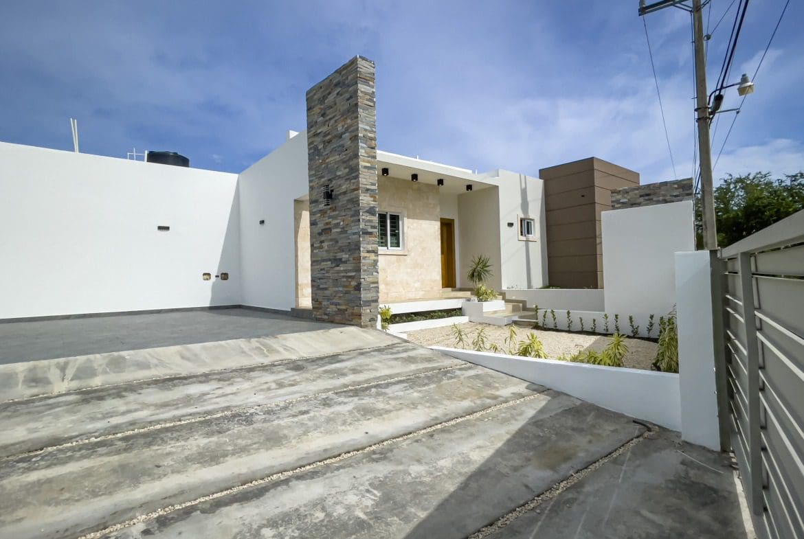 buyDRproperty Modern villa for sale in Sosua Hills with stone accents and concrete driveway Sosua Real Estate
