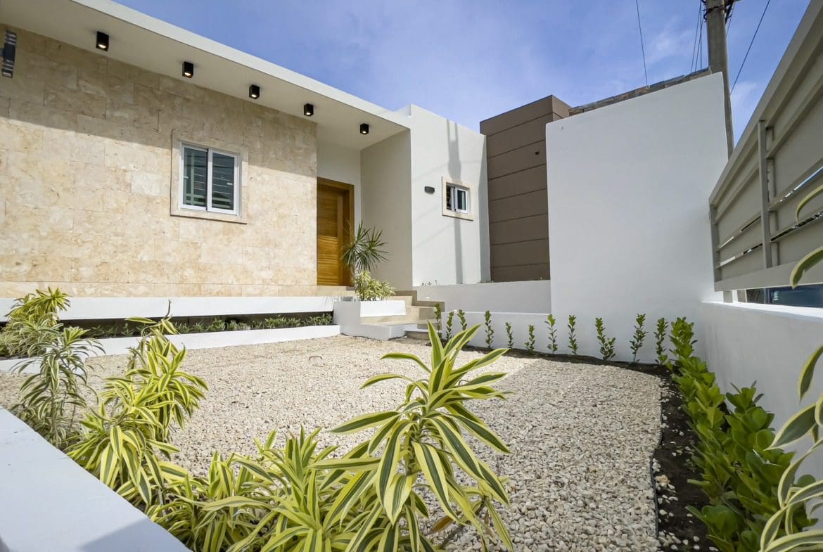 buyDRproperty Modern villa for sale in Sosua Hills with stone facade and landscaped yard. Sosua Real Estate