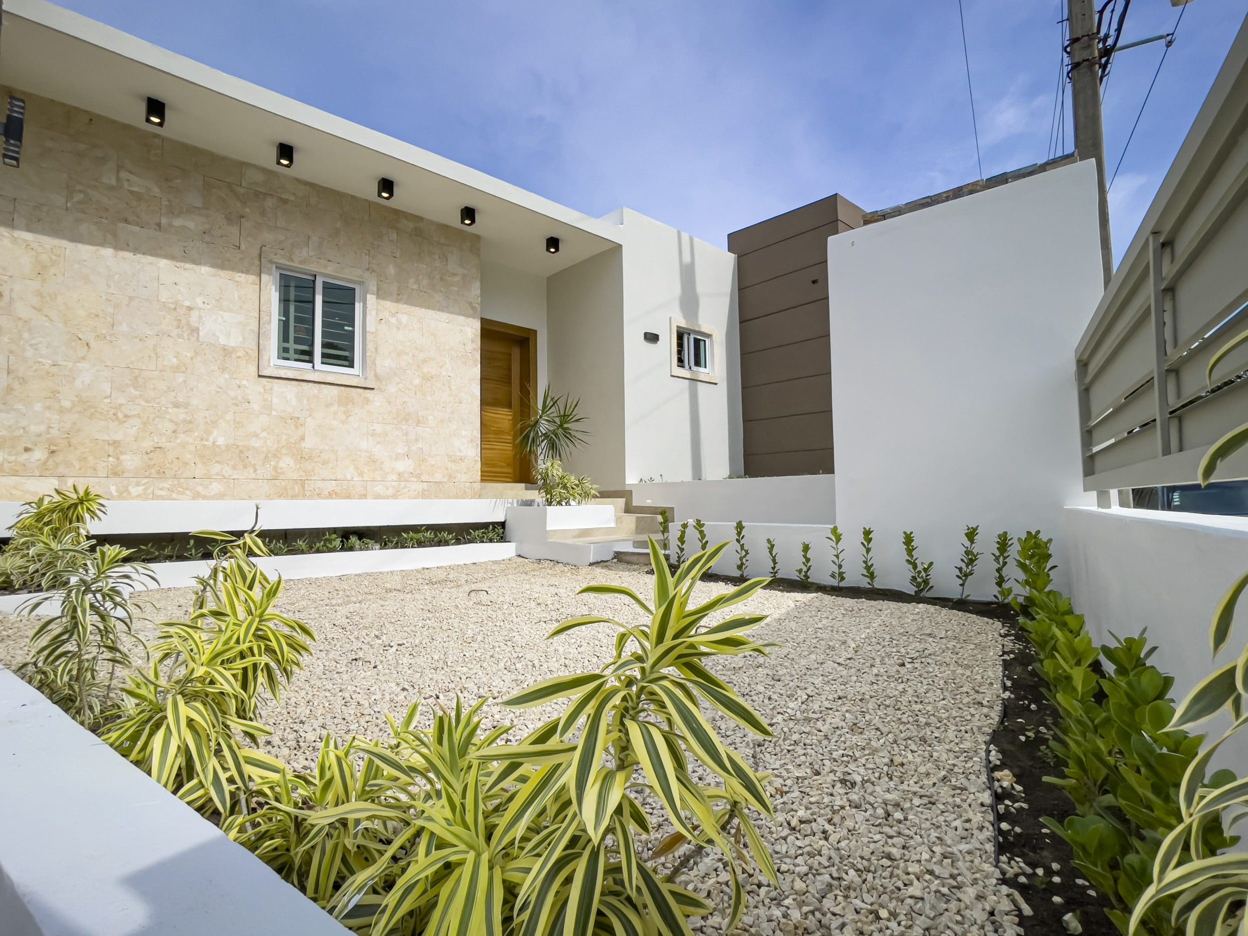 buyDRproperty Modern villa for sale in Sosua Hills with stone facade and landscaped yard. Sosua Real Estate