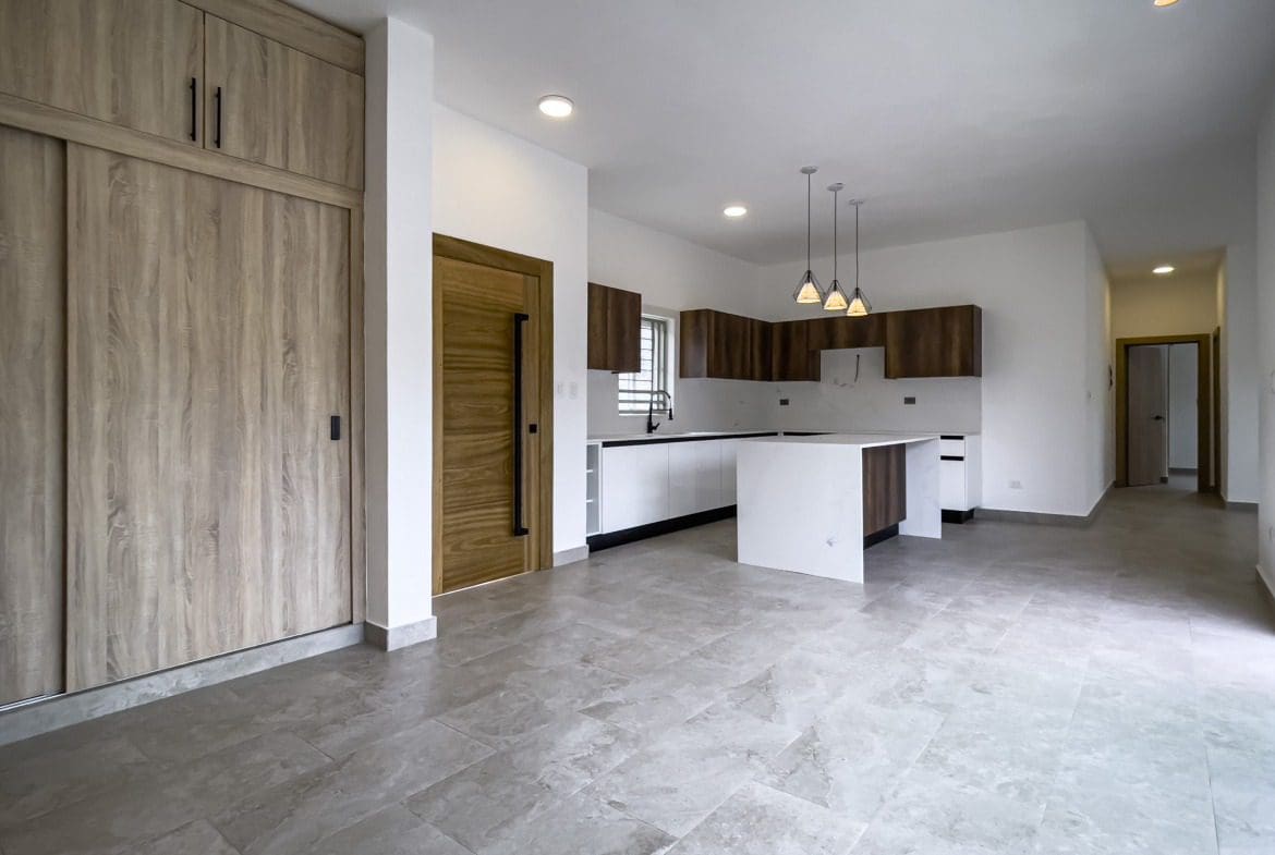 buyDRproperty Modern kitchen with white countertops and wood cabinets. Villa for sale. Sosua Real Estate