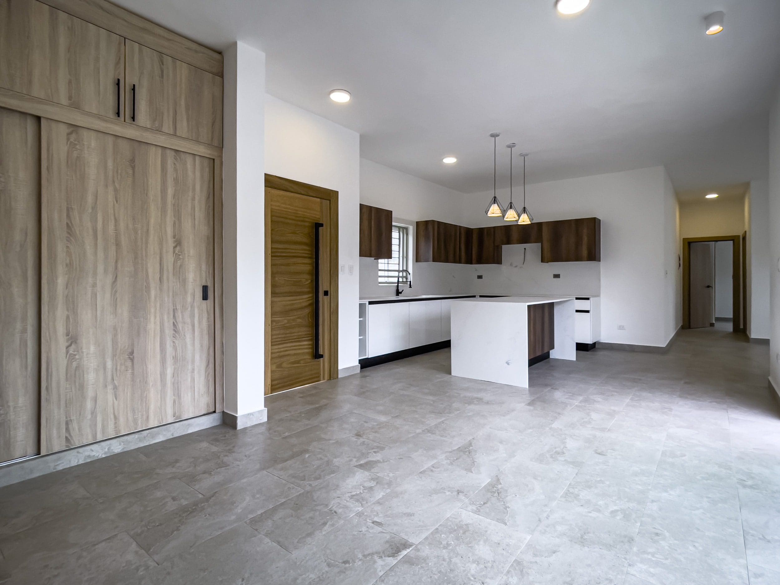 buyDRproperty Modern kitchen with white countertops and wood cabinets. Villa for sale. Sosua Real Estate