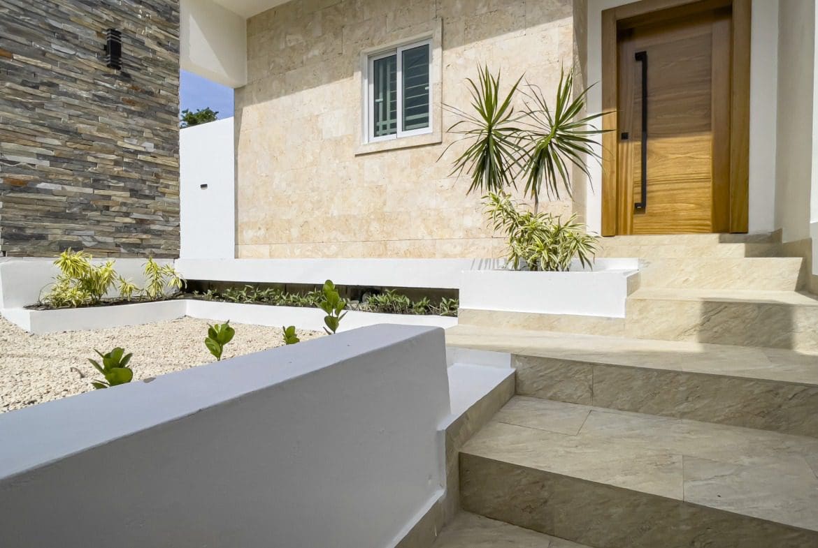 buyDRproperty Modern villa for sale with steps leading to the wooden door Sosua Real Estate