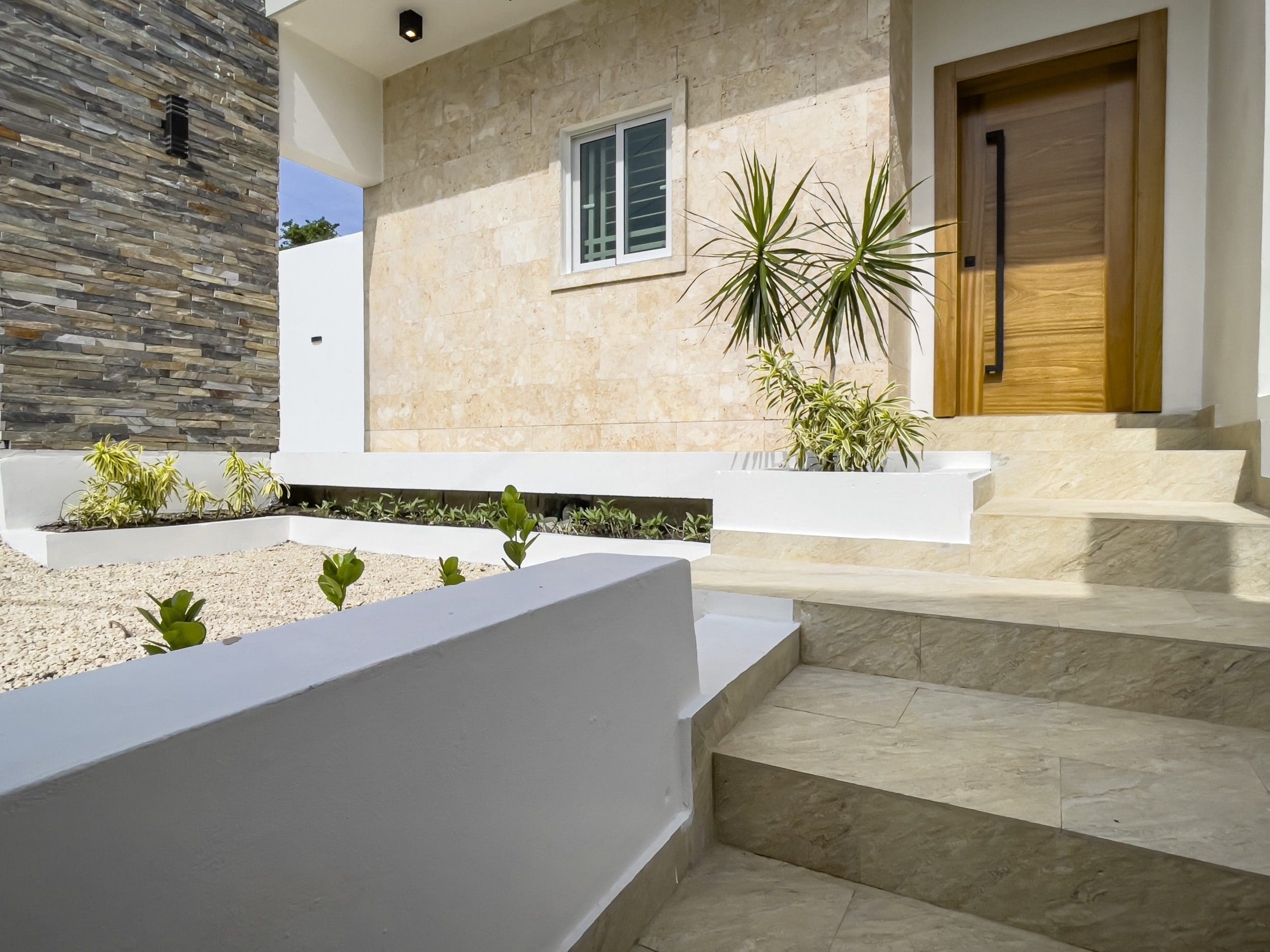 buyDRproperty Modern villa for sale with steps leading to the wooden door Sosua Real Estate