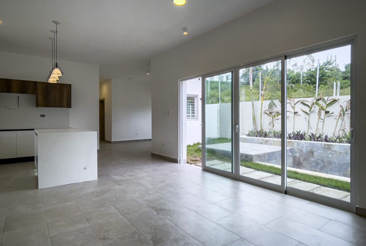 buyDRproperty Bright modern villa interior with sliding glass doors and a view of the garden. Villa for sale. Sosua Real Estate