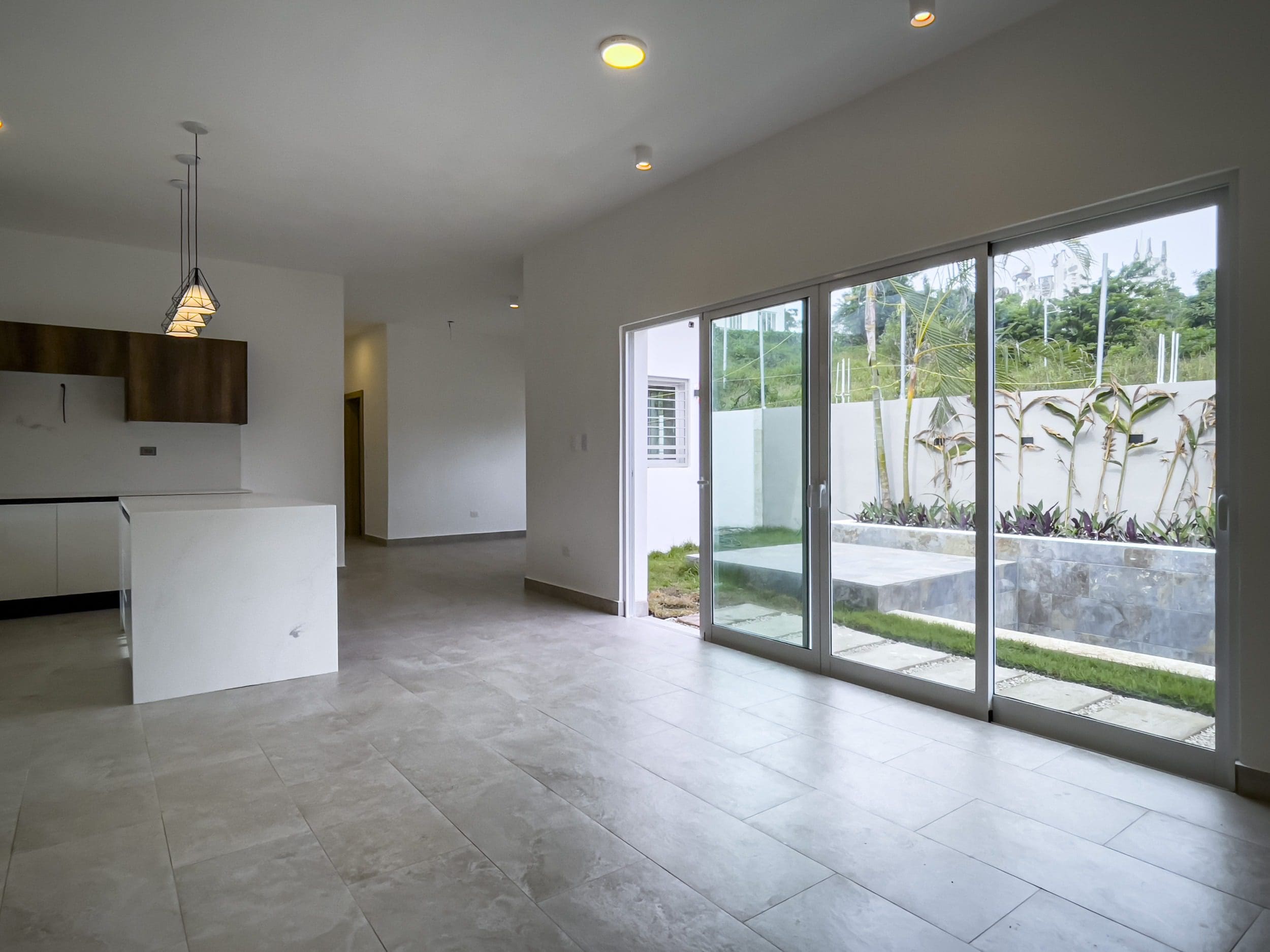 buyDRproperty Bright modern villa interior with sliding glass doors and a view of the garden. Villa for sale. Sosua Real Estate