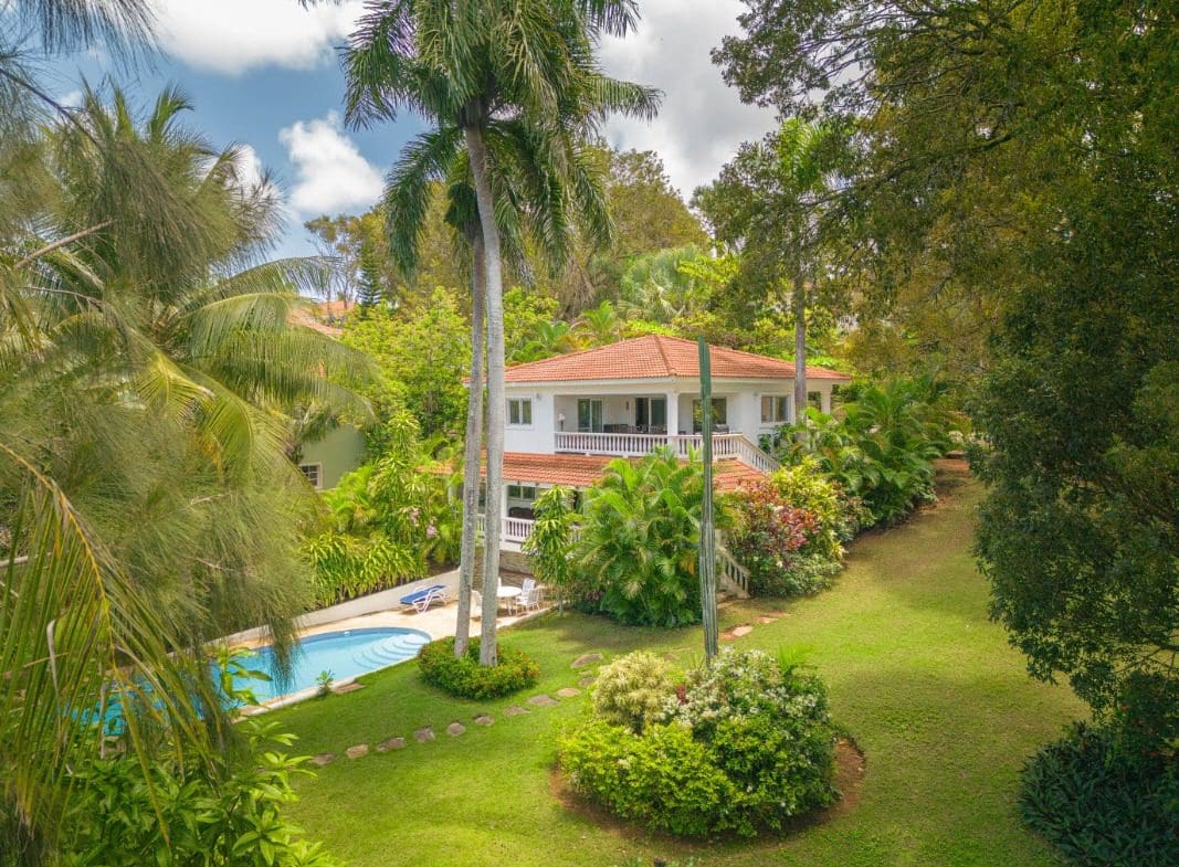 buyDRproperty Tropical villa for sale with a pool surrounded by lush tropical landscaping. Sosua Real Estate
