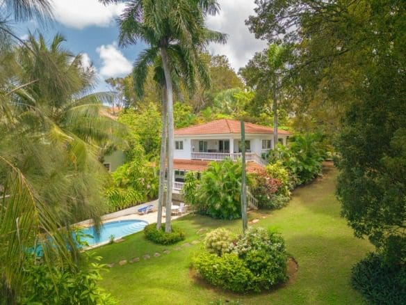 buyDRproperty Tropical villa for sale with a pool surrounded by lush tropical landscaping. Sosua Real Estate