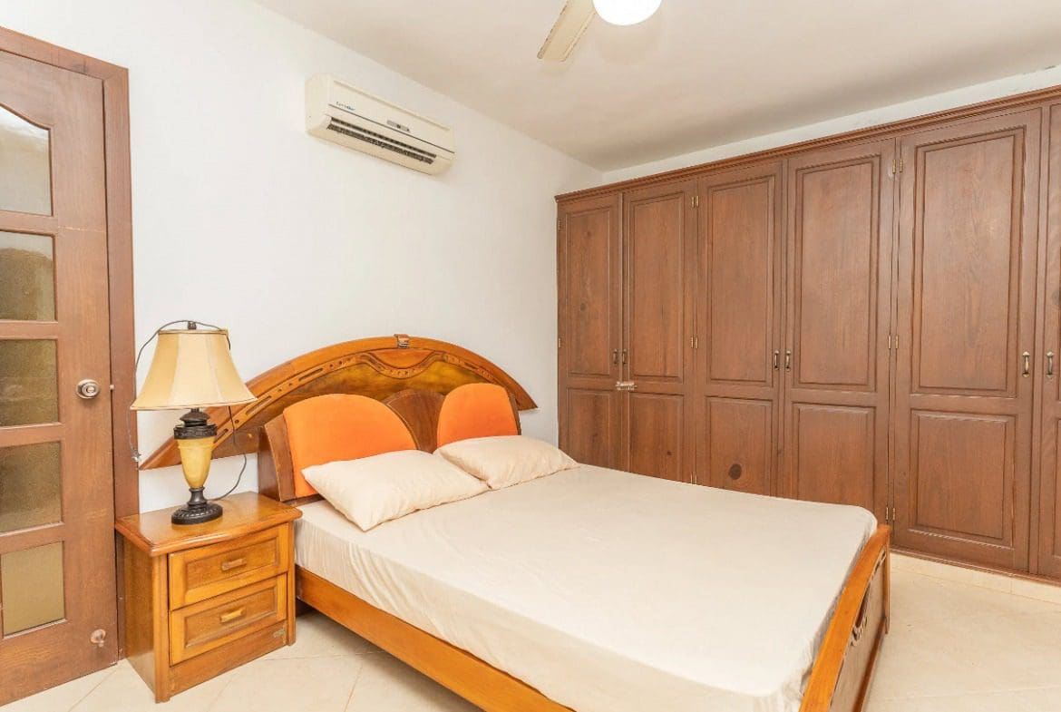 buyDRproperty Bedroom in a tropical villa with wooden furniture, bed, and air conditioning. Sosua Real Estate