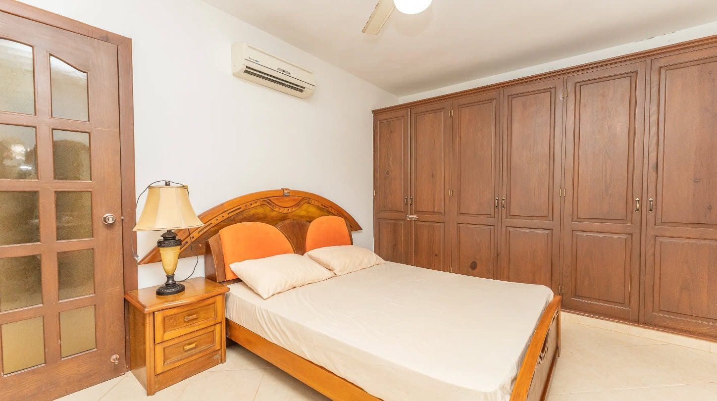 buyDRproperty Bedroom in a tropical villa with wooden furniture, bed, and air conditioning. Sosua Real Estate