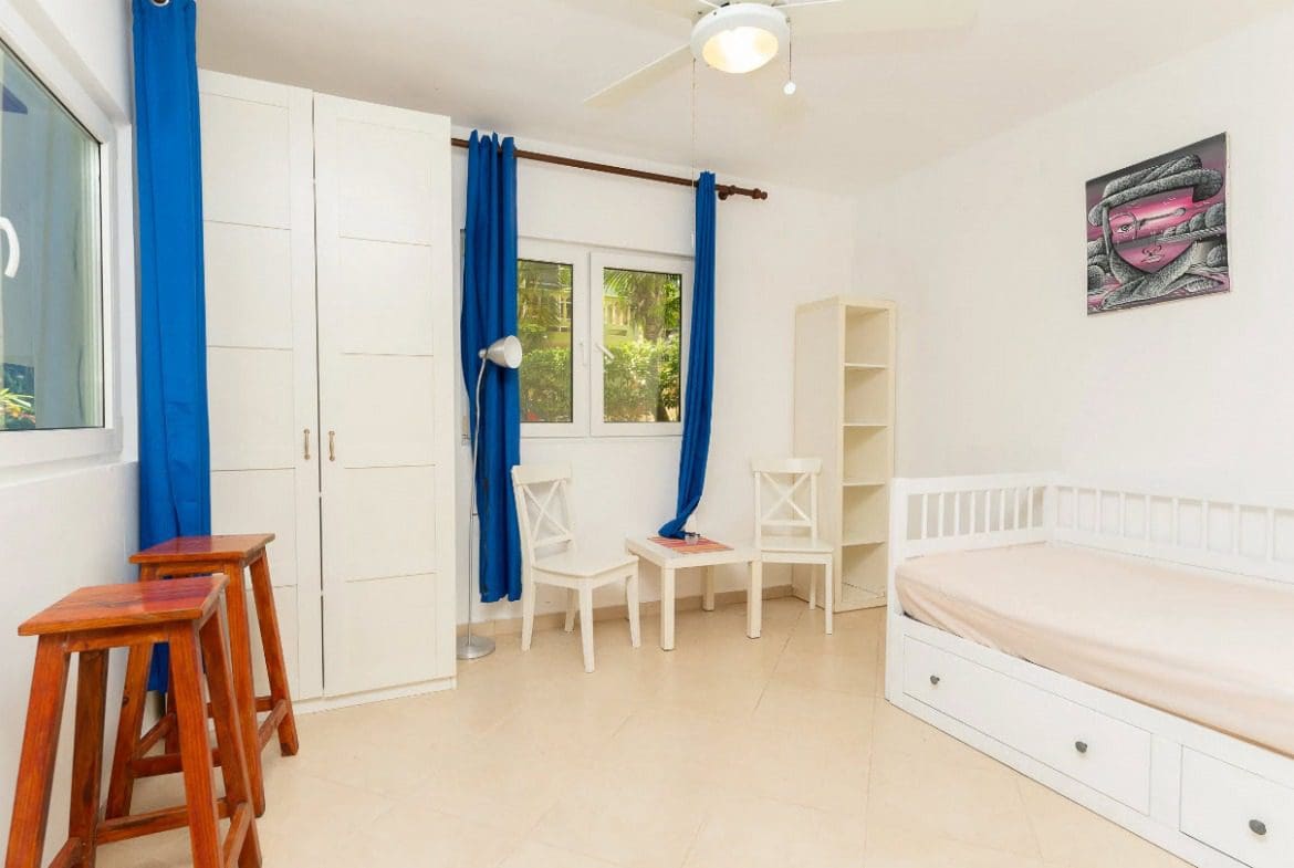 buyDRproperty Bright bedroom with blue curtains and tropical decor. Sosua Real Estate