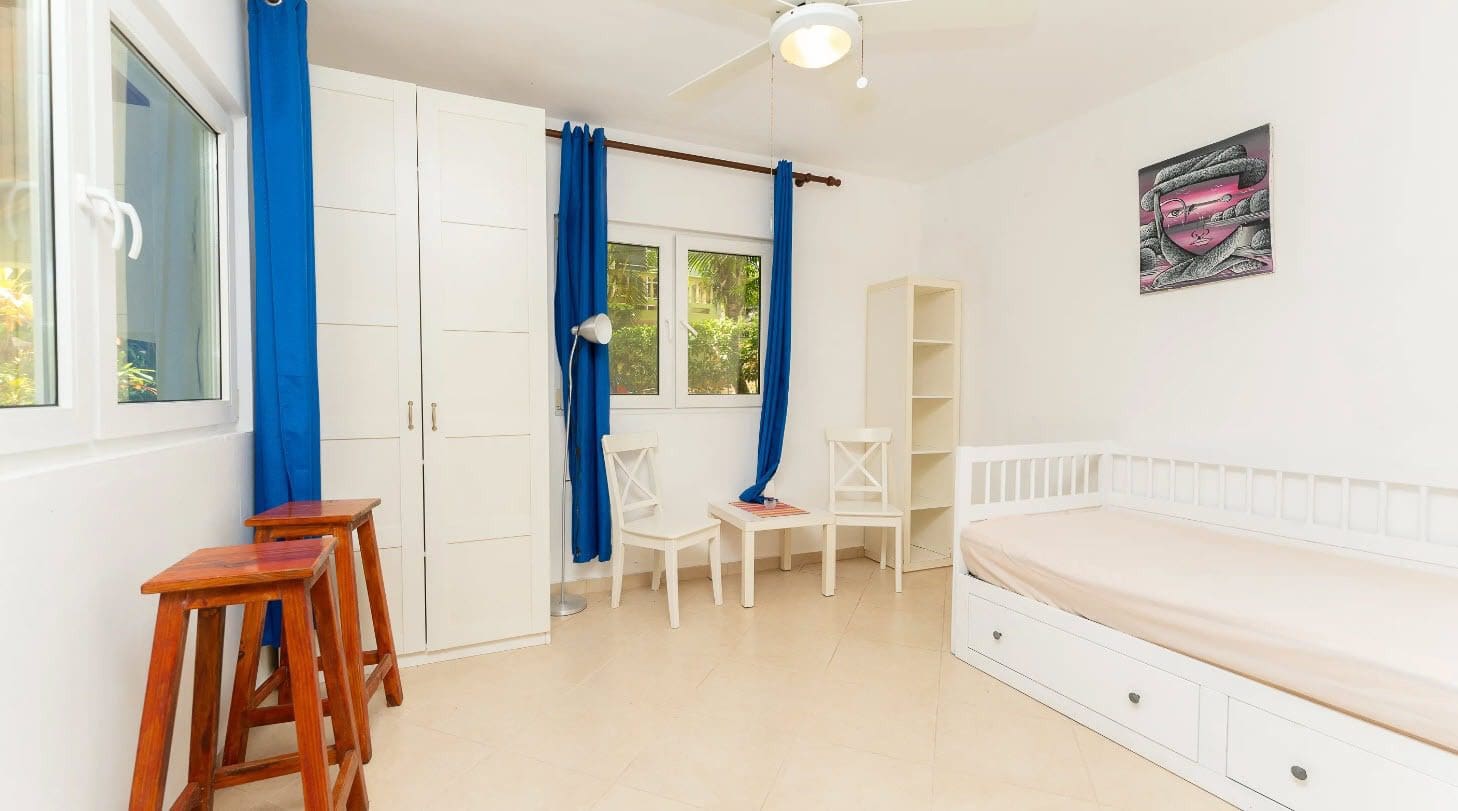 buyDRproperty Bright bedroom with blue curtains and tropical decor. Sosua Real Estate