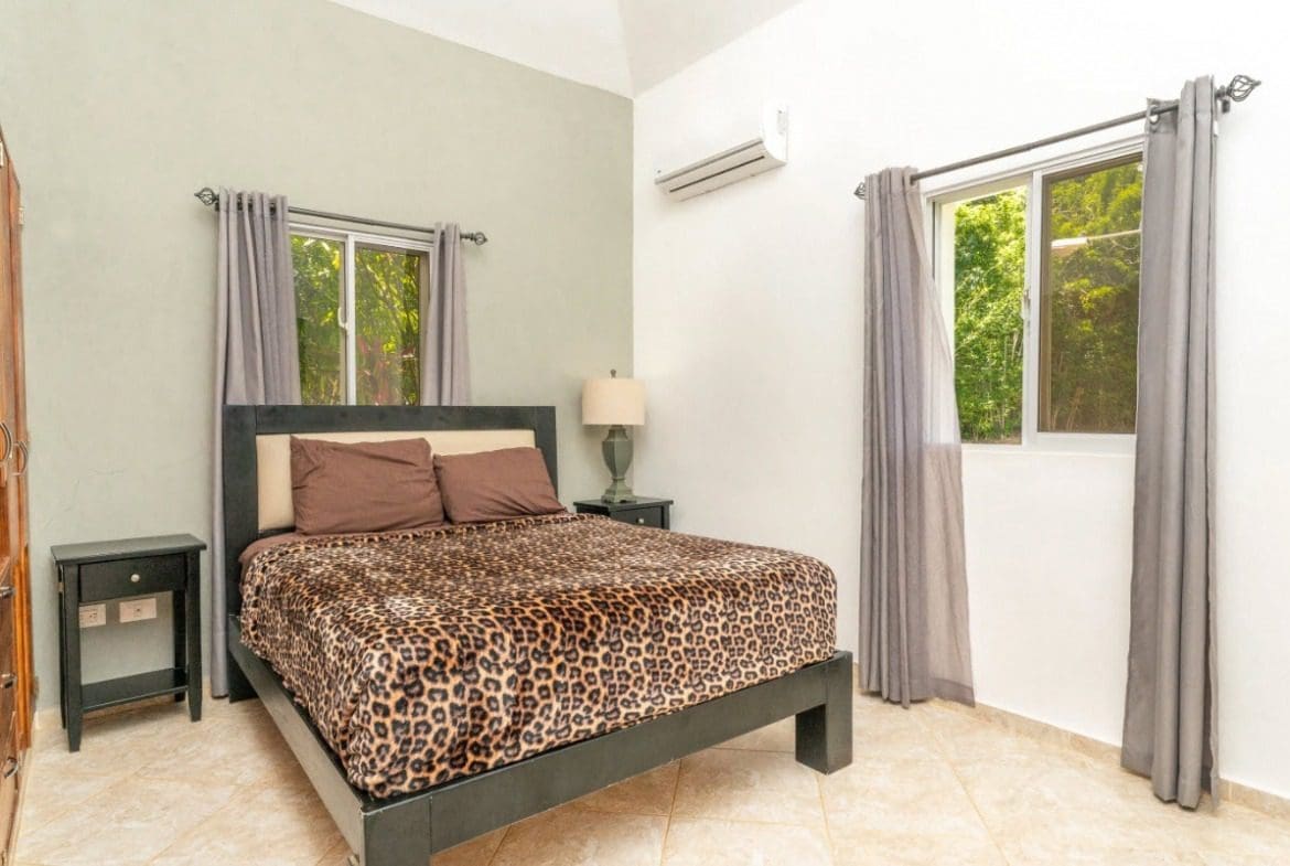buyDRproperty Bedroom with leopard print blanket, curtains, and nightstand Sosua Real Estate