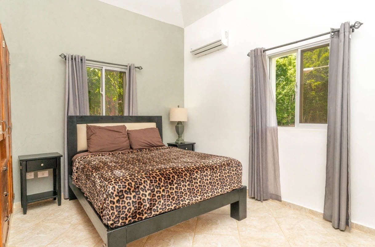 buyDRproperty Bedroom with leopard print blanket, curtains, and nightstand Sosua Real Estate