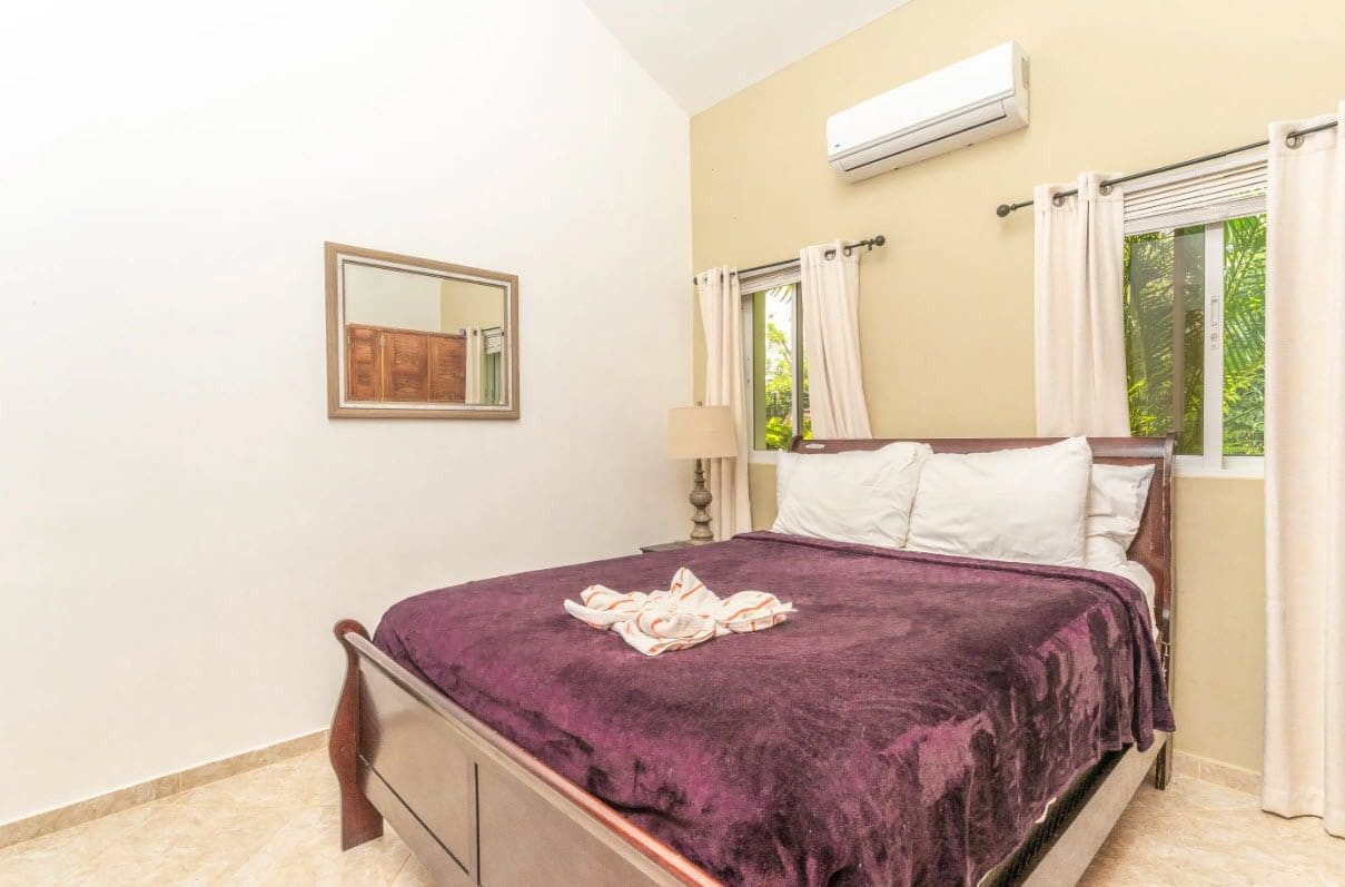 buyDRproperty Bedroom in a villa with a purple blanket and white pillows. Sosua Real Estate