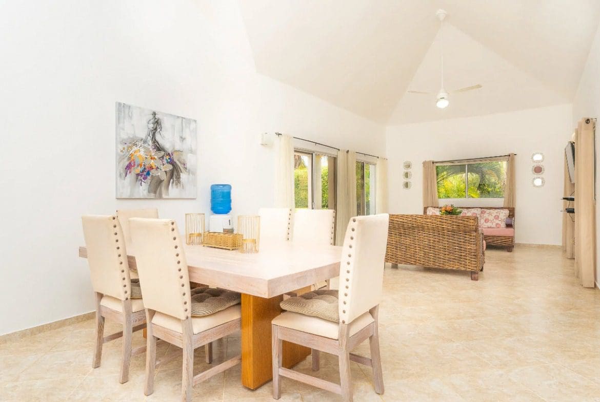 buyDRproperty Dining area in a beautiful villa for sale, featuring a table, chairs, and artwork. Sosua Real Estate