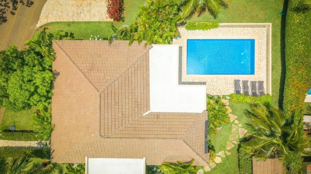 buyDRproperty Aerial view of a villa with a pool and landscaping. For sale in a gated community. Sosua Real Estate