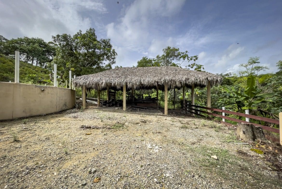 buyDRproperty Thatched roof structure on a building lot with a gravel area. Sosua Real Estate