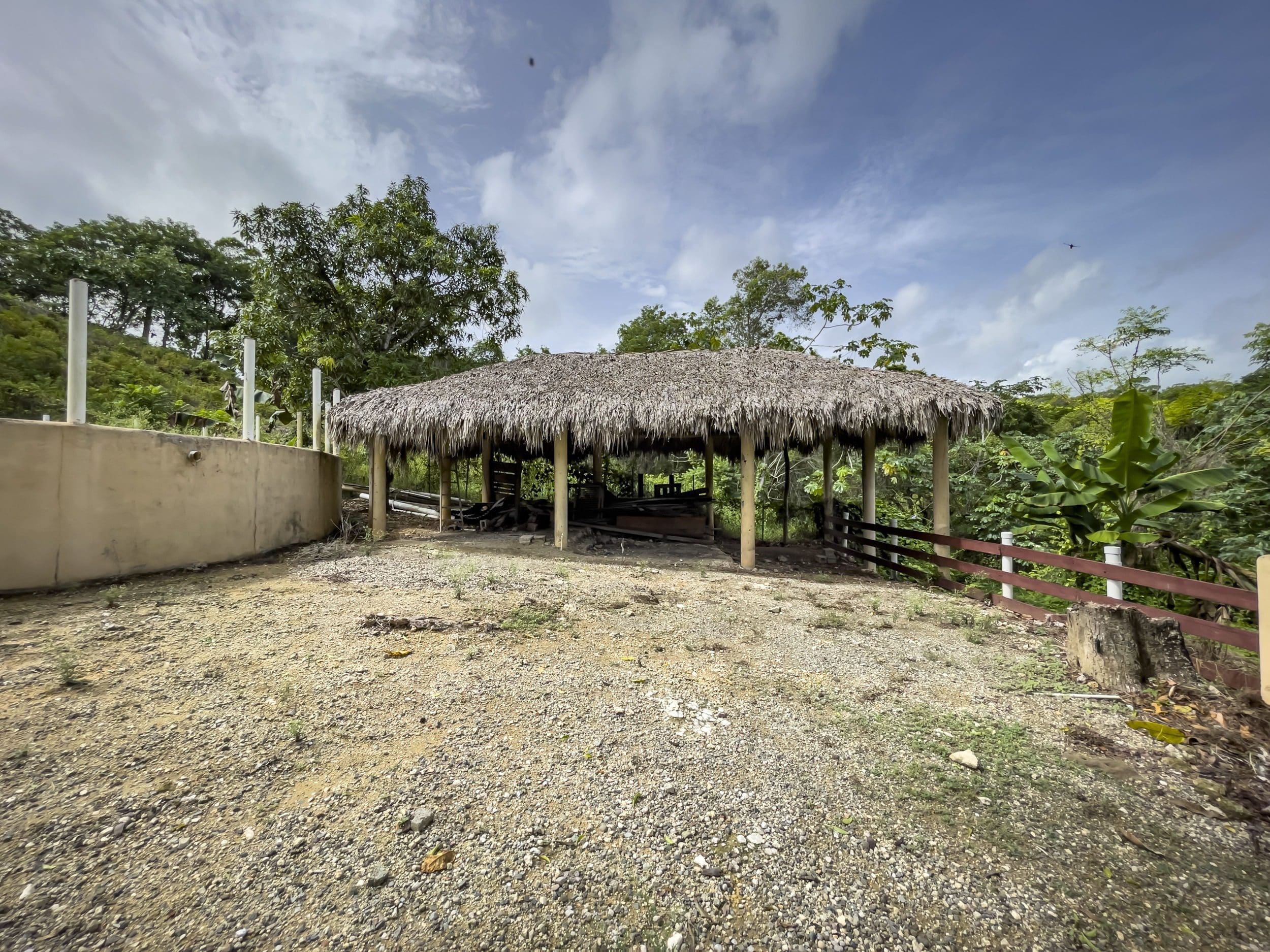 buyDRproperty Thatched roof structure on a building lot with a gravel area. Sosua Real Estate