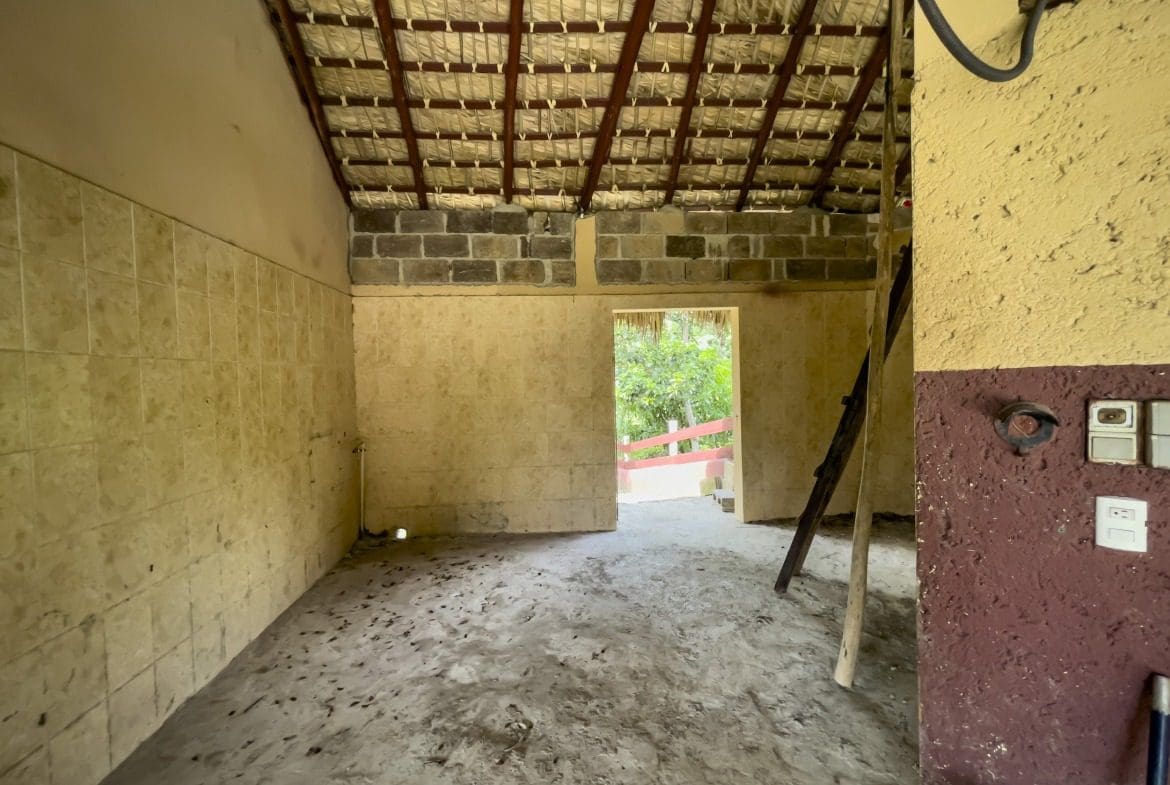 buyDRproperty Interior of a building lot, in disrepair. The room has a tiled wall and open doorway. Sosua Real Estate