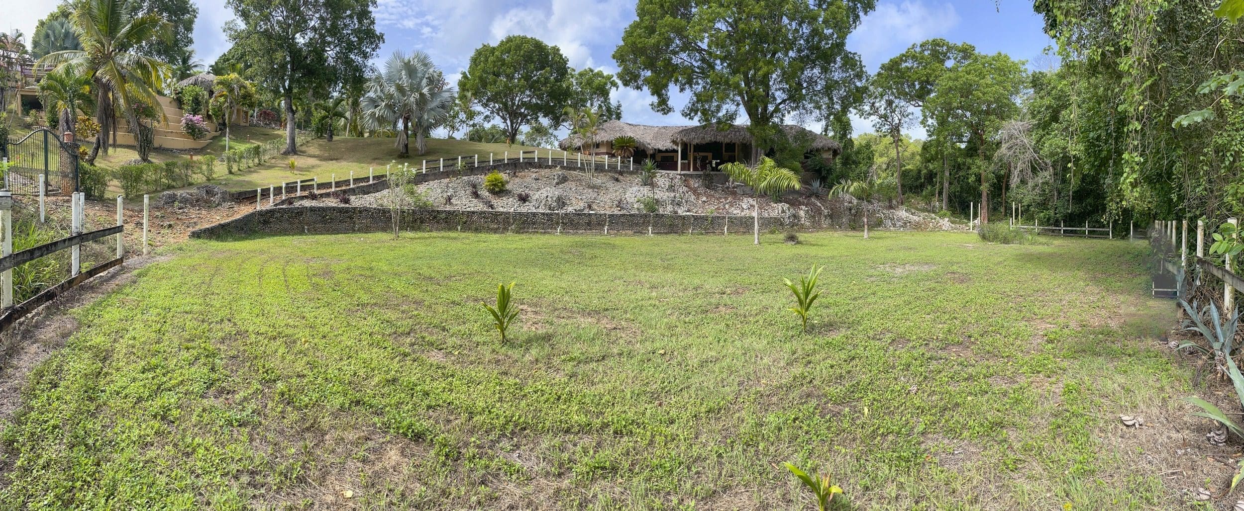 buyDRproperty Building lot with thatched roof and grassy area Sosua Real Estate