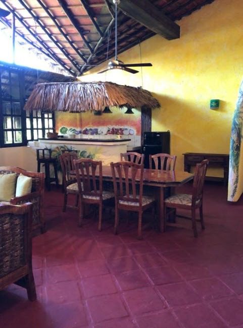 buyDRproperty Restaurant dining area with wooden table and chairs, part of a Hotel. Sosua Real Estate