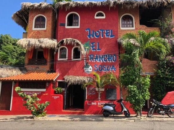 buyDRproperty Hotel El Rancho Sosua, a colorful hotel and restaurant with scooter parked outside. Sosua Real Estate