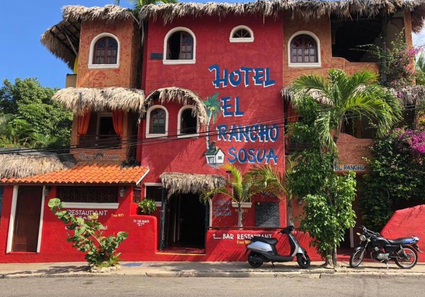 buyDRproperty Hotel El Rancho Sosua, a colorful hotel and restaurant with scooter parked outside. Sosua Real Estate