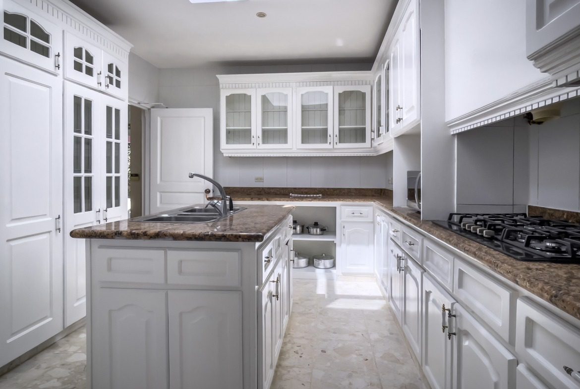 buyDRproperty Elegant white kitchen with marble countertops, part of a prime villa. Sosua Real Estate