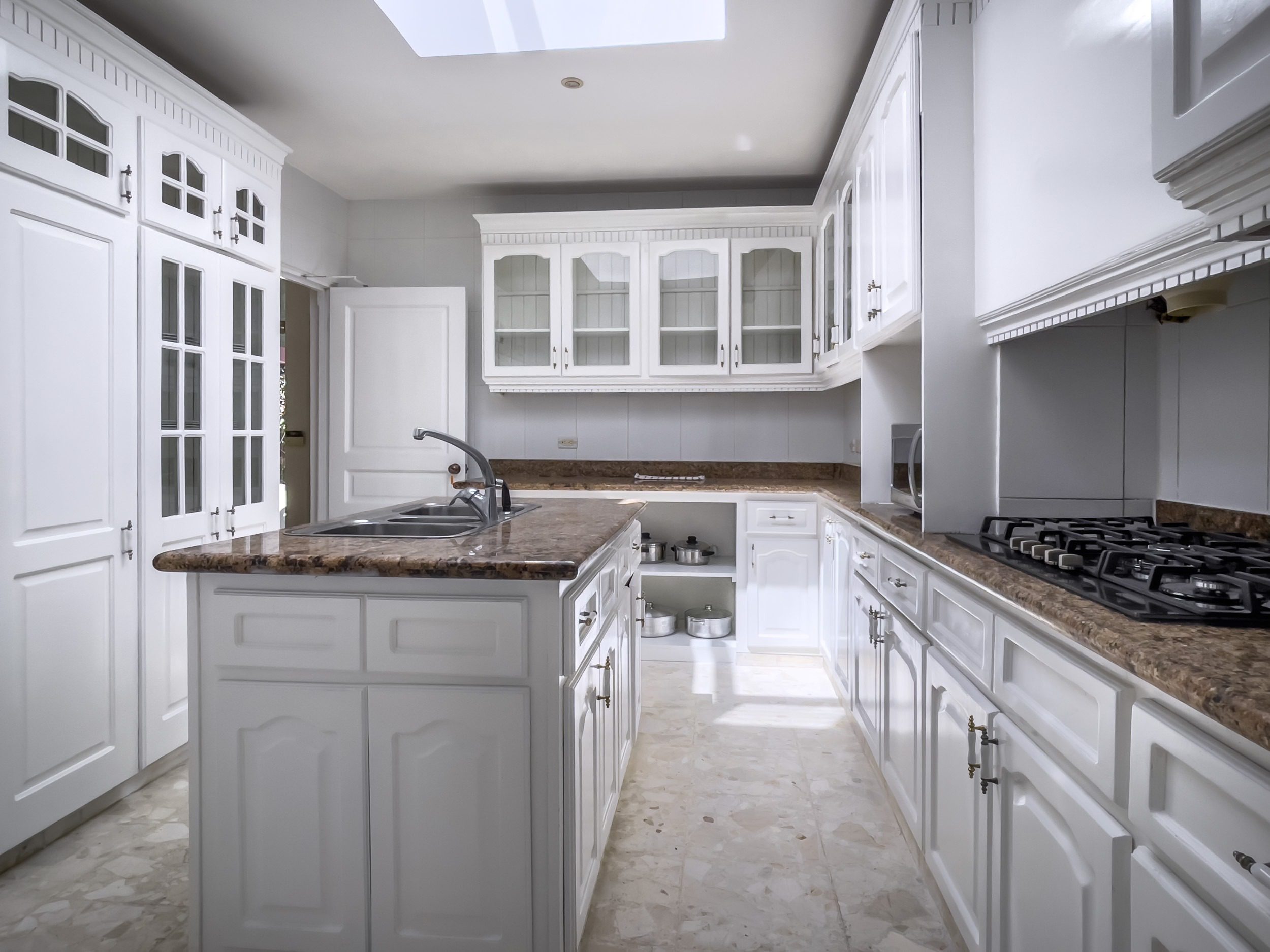 buyDRproperty Elegant white kitchen with marble countertops, part of a prime villa. Sosua Real Estate