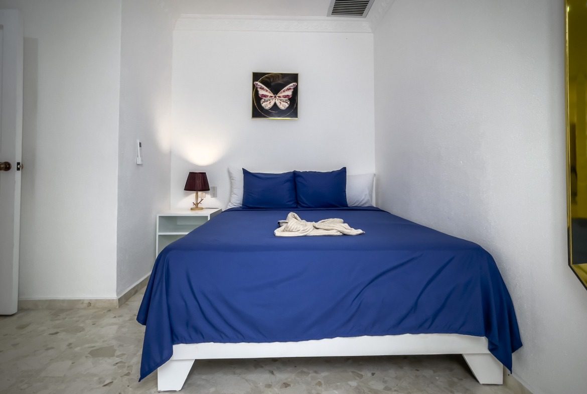 buyDRproperty Cozy bedroom in a prime villa with blue bedding and butterfly artwork Sosua Real Estate
