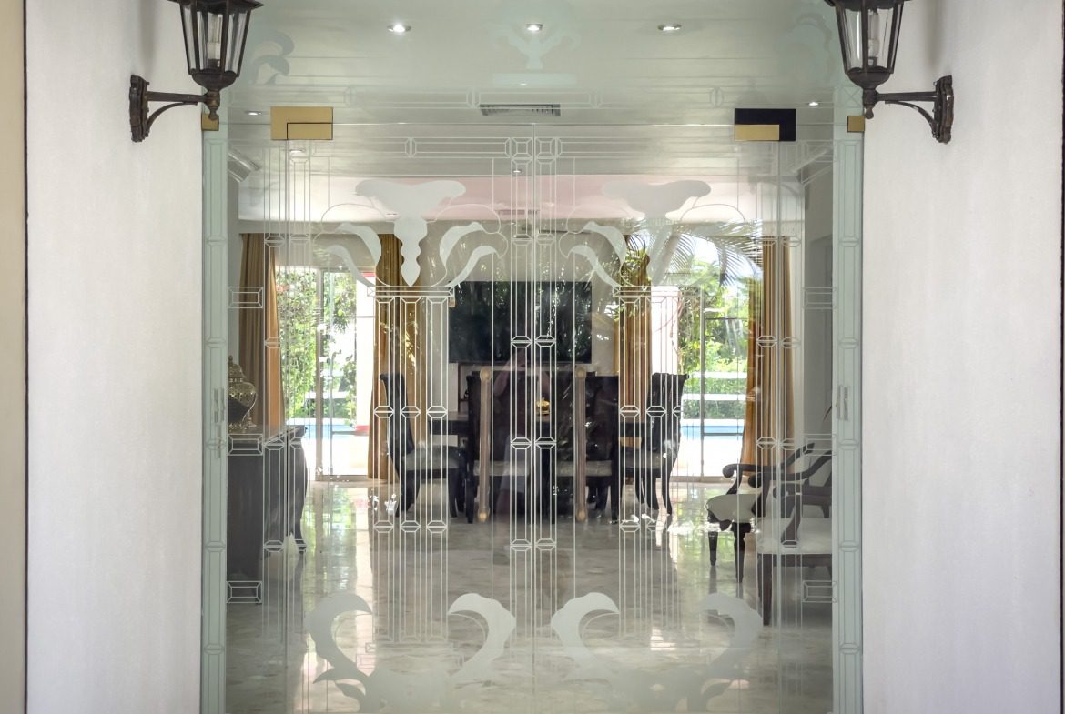 buyDRproperty Ornate glass door with etched design and lanterns, leading to a dining area. Prime. Sosua Real Estate