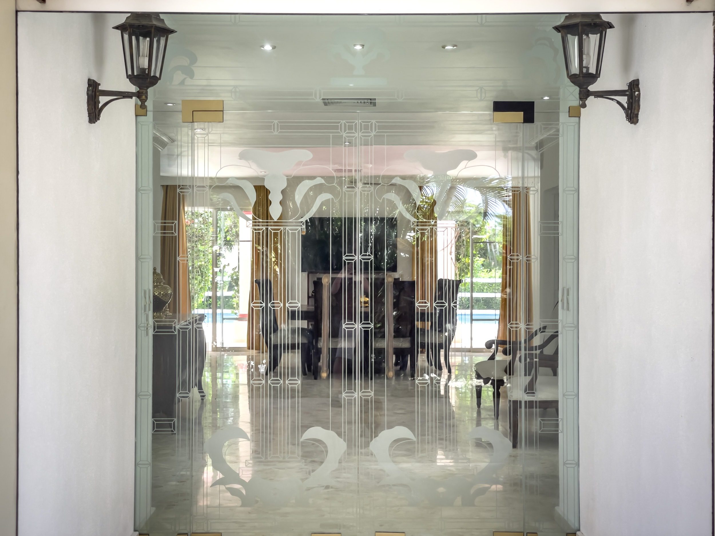 buyDRproperty Ornate glass door with etched design and lanterns, leading to a dining area. Prime. Sosua Real Estate
