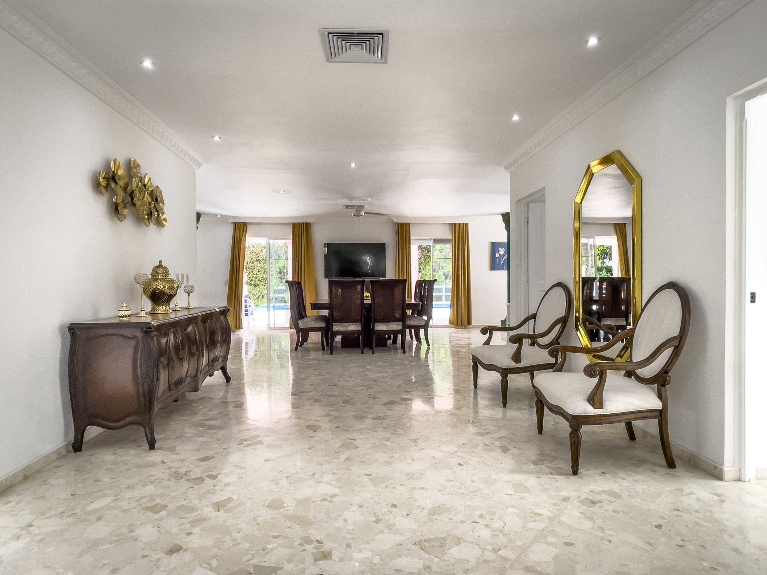 buyDRproperty Elegant villa interior with marble floor, ornate furniture, and dining area, a prime property. Sosua Real Estate